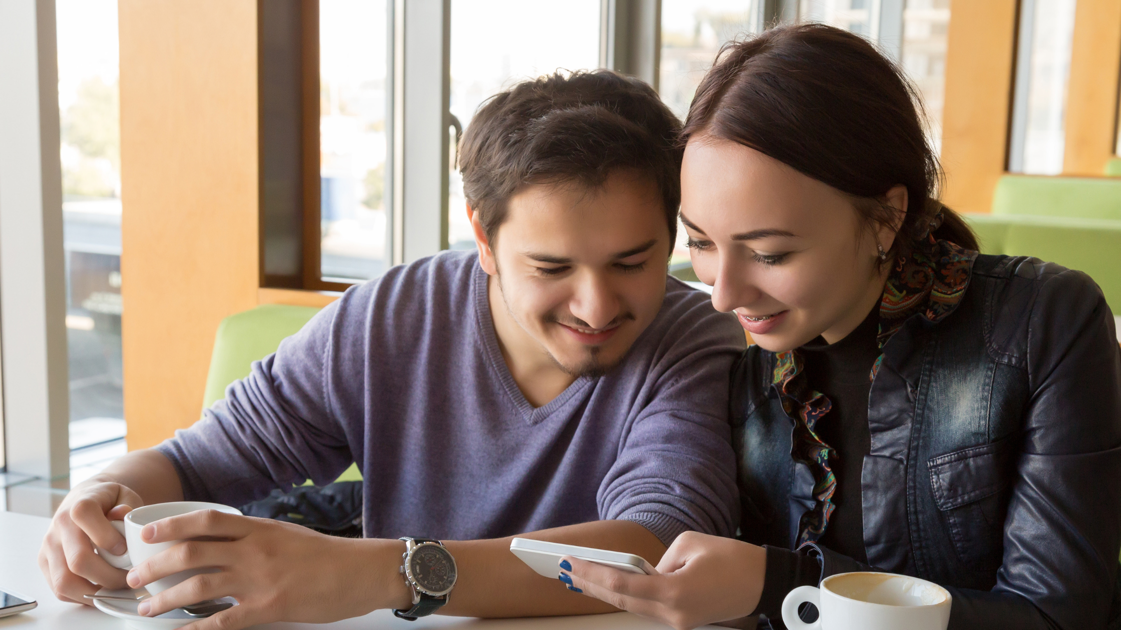 Coppia al ristorante che consulta il menu digitale sul telefono, Come cambiare gratis le immagini al menu digitale.